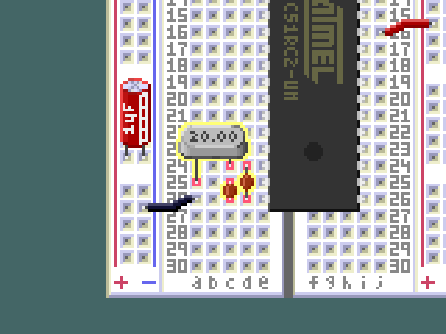 Detail view of the crystal oscillator and load capacitors on the breadboard.